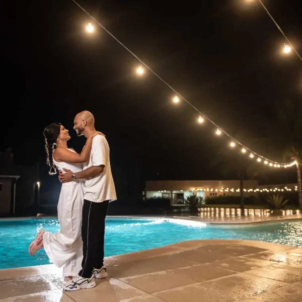 Casal se beijando ao fundo a piscina