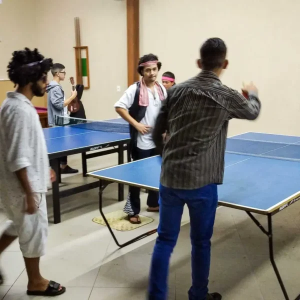 Confraternização dos jovens jogando tênis de mesa